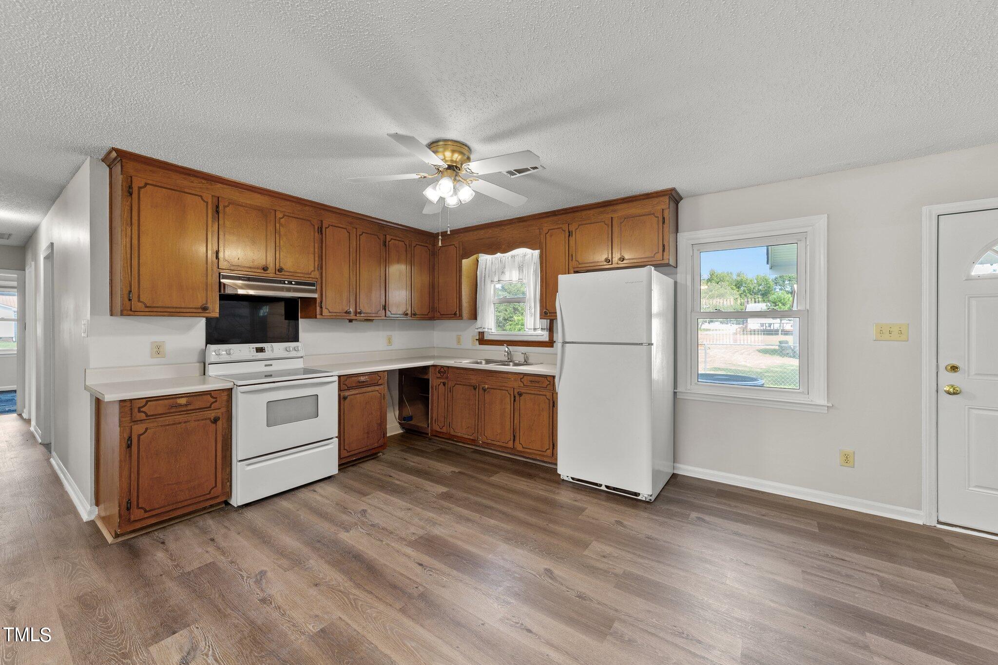 4868 Buffalo Road Selma, NC 27576 - Photo 10 of 48 a kitchen with granite countertop stainless steel appliances a refrigerator cabinets and wooden floor