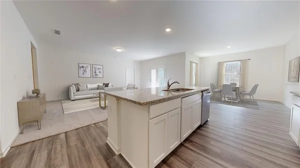 a kitchen with stainless steel appliances kitchen island a stove a sink a refrigerator and cabinets