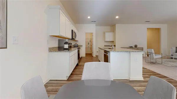 a living room with furniture and kitchen view
