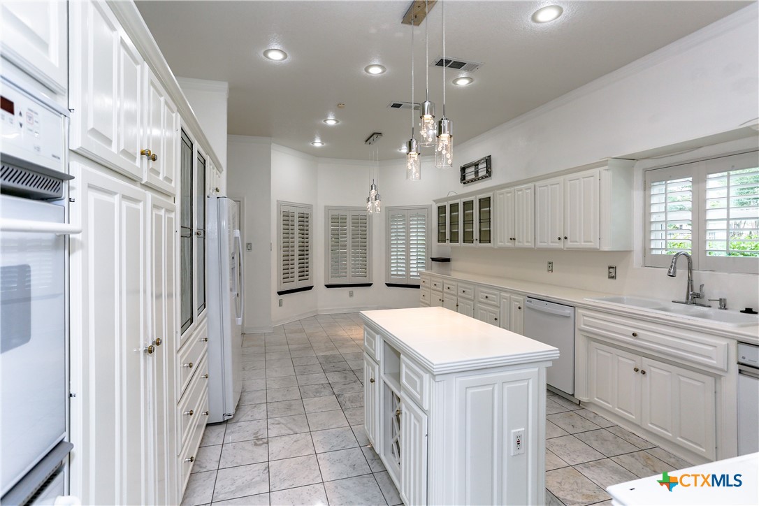 2110 Lakeview Loop Killeen, TX 76543 - Photo 26 of 42 a large white kitchen with a large island oven a sink stainless steel appliances and a window