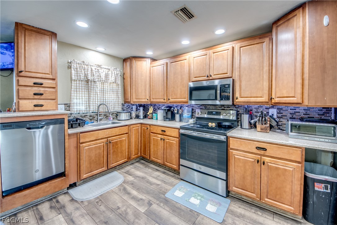 3015 8th Street Southwest Lehigh Acres, FL 33976 - Photo 13 of 34 a kitchen with stainless steel appliances granite countertop a stove a sink and a microwave
