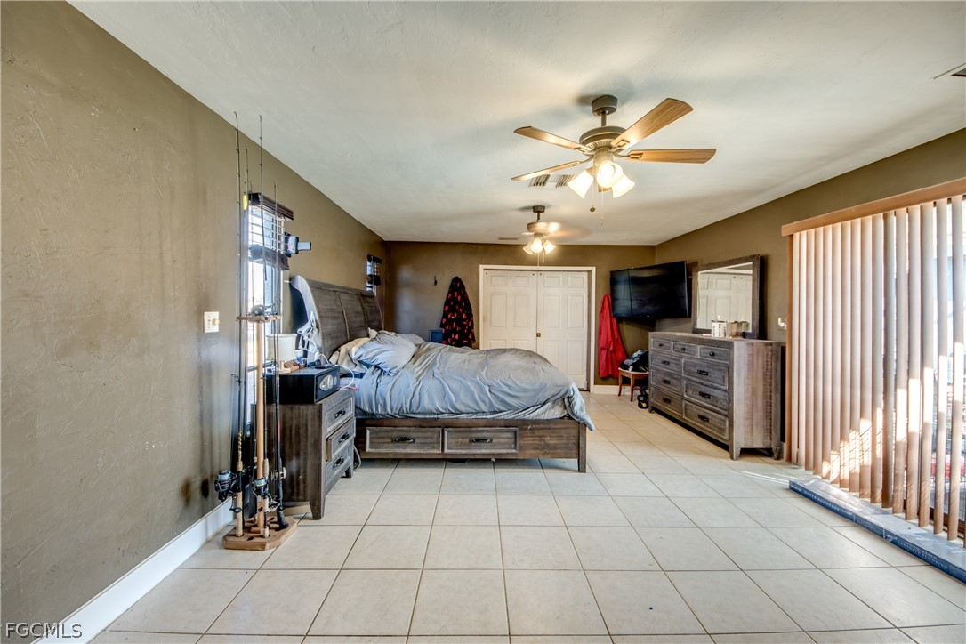 3015 8th Street Southwest Lehigh Acres, FL 33976 - Photo 15 of 34 a spacious bedroom with a bed and a chandelier