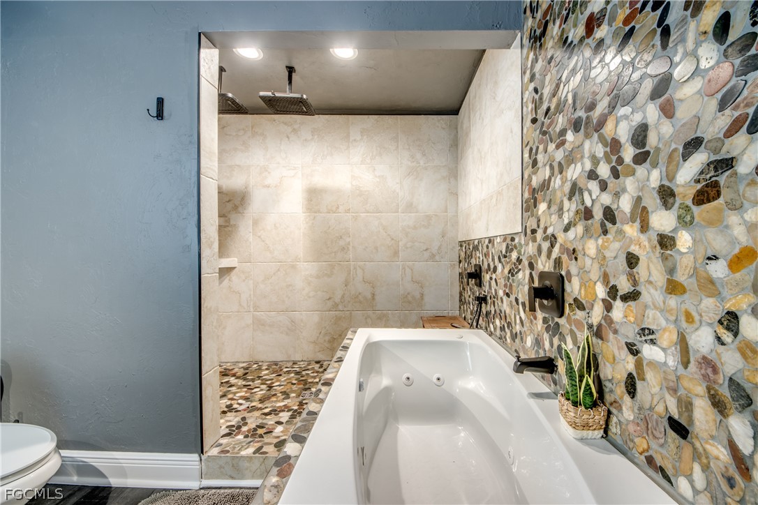 3015 8th Street Southwest Lehigh Acres, FL 33976 - Photo 18 of 34 a bathroom with a shower and a toilet