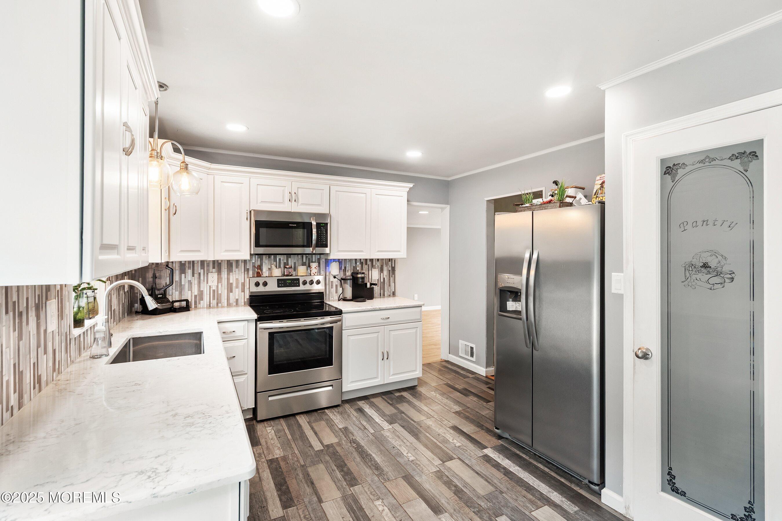 13 Rhode Island Drive Jackson, NJ 08527 - Photo 7 of 30 a kitchen with stainless steel appliances granite countertop a refrigerator and a stove top oven