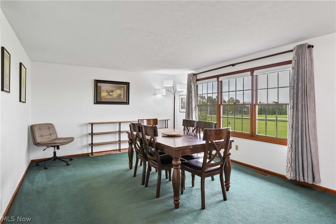 9550 Spencer Road Homerville, OH 44235 - Photo 9 of 50 Dining Room featuring a large picture window with wood-finish trim, offering expansive outdoor scenery