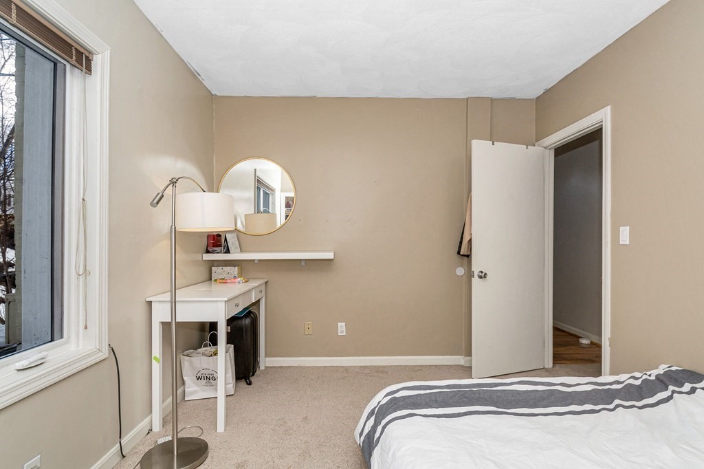 42 Epping Street, Unit 2 Lowell, MA 01852 - Photo 16 of 33 a bedroom with a bed and a chandelier