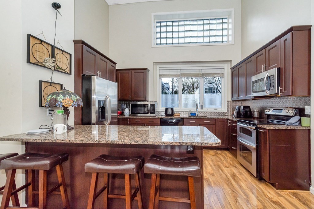 42 Epping Street, Unit 2 Lowell, MA 01852 - Photo 2 of 33 a large kitchen with granite countertop a stove a sink a dining table and chairs