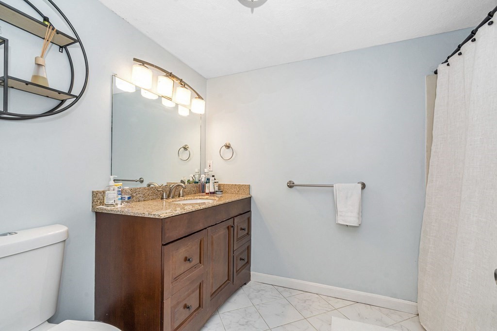 42 Epping Street, Unit 2 Lowell, MA 01852 - Photo 24 of 33 a bathroom with a granite countertop sink a toilet and a mirror