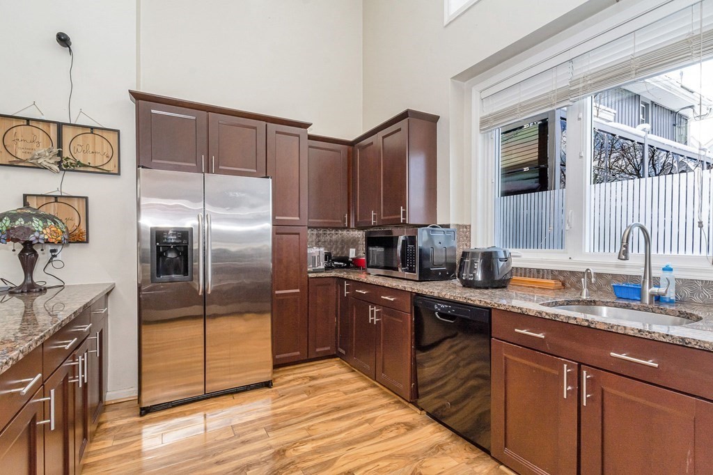 42 Epping Street, Unit 2 Lowell, MA 01852 - Photo 3 of 33 a kitchen with stainless steel appliances granite countertop a refrigerator and a sink