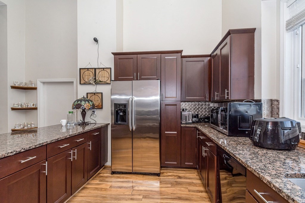 42 Epping Street, Unit 2 Lowell, MA 01852 - Photo 4 of 33 a kitchen with stainless steel appliances granite countertop a sink refrigerator and cabinets