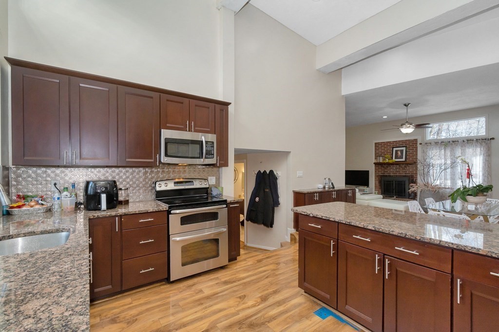 42 Epping Street, Unit 2 Lowell, MA 01852 - Photo 5 of 33 a kitchen with granite countertop wooden cabinets and a stainless steel appliances