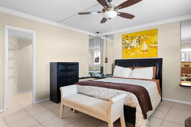 a spacious bedroom with a bed and ceiling fan
