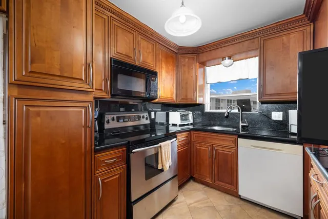 a kitchen with stainless steel appliances granite countertop a stove sink microwave and cabinets