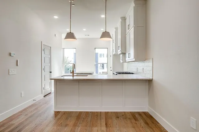 a kitchen with wooden floor and window