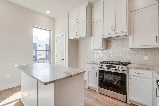 a kitchen with cabinets appliances and a wooden floor