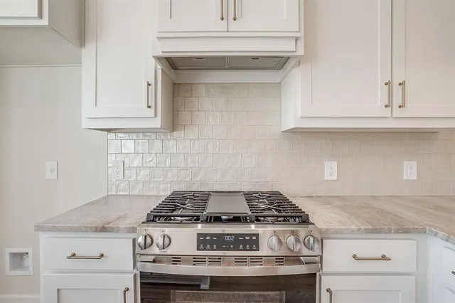 a stove top oven sitting inside of a kitchen