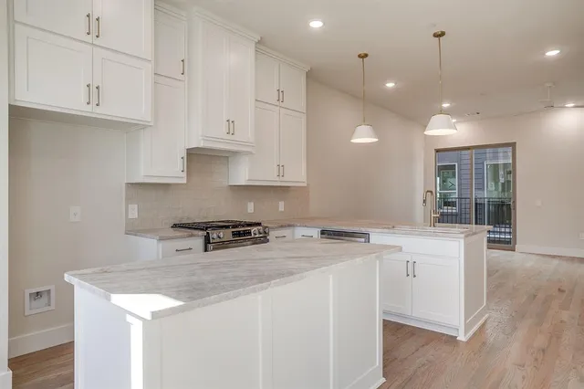 a kitchen that has a sink a stove and cabinets