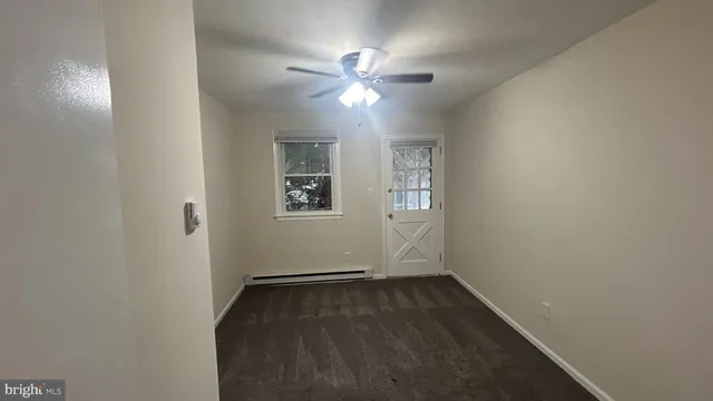 an empty room with a window and ceiling fan