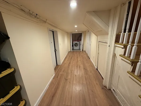 a view of a hallway with wooden floor and staircase