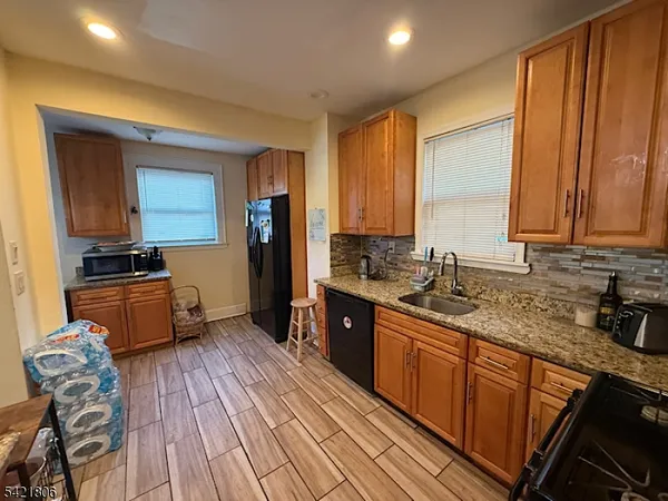 a kitchen with stainless steel appliances granite countertop wooden floors a stove top oven a sink and dishwasher
