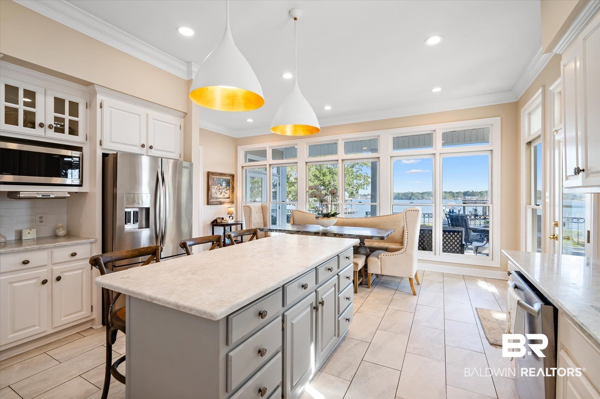4930 River Trace Theodore, AL 36582 - Photo 12 of 57 Kitchen featuring appliances with stainless steel finishes, a kitchen island, a kitchen breakfast bar, white cabinetry, and decorative light fixtures