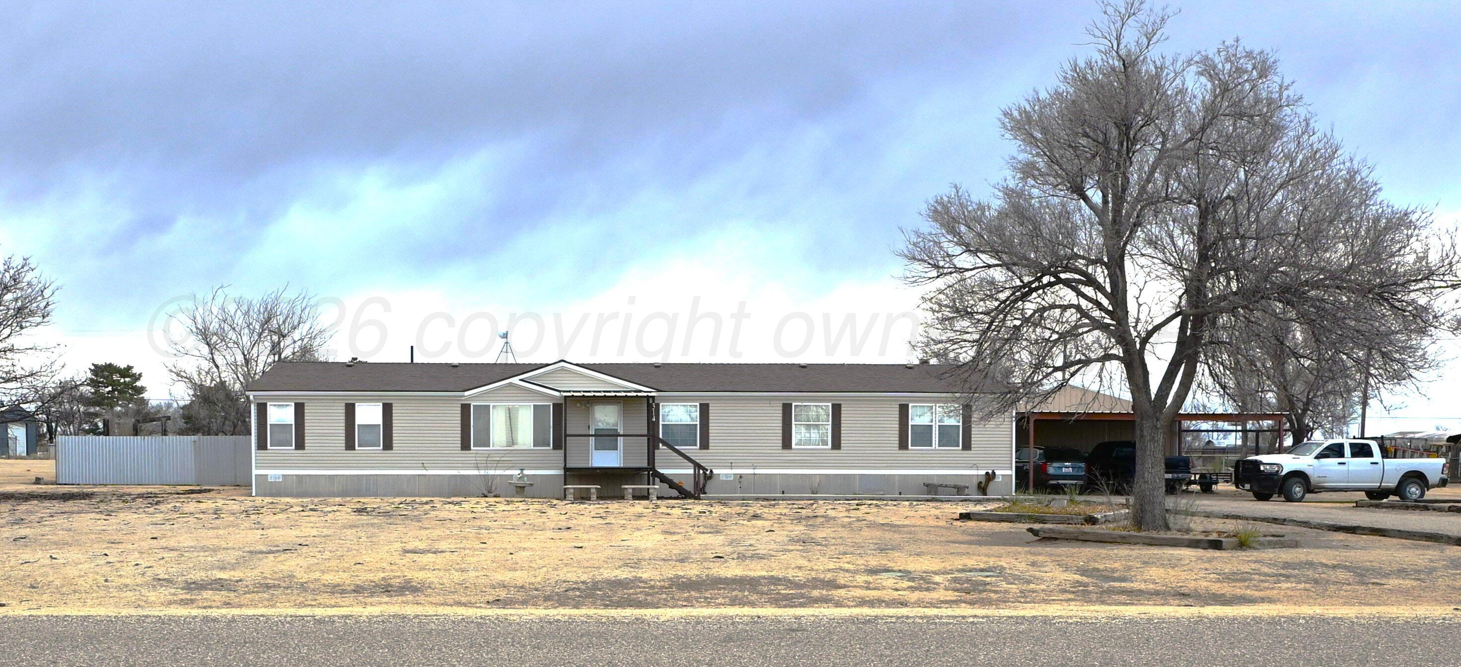 a front view of a house with a yard covered with snow