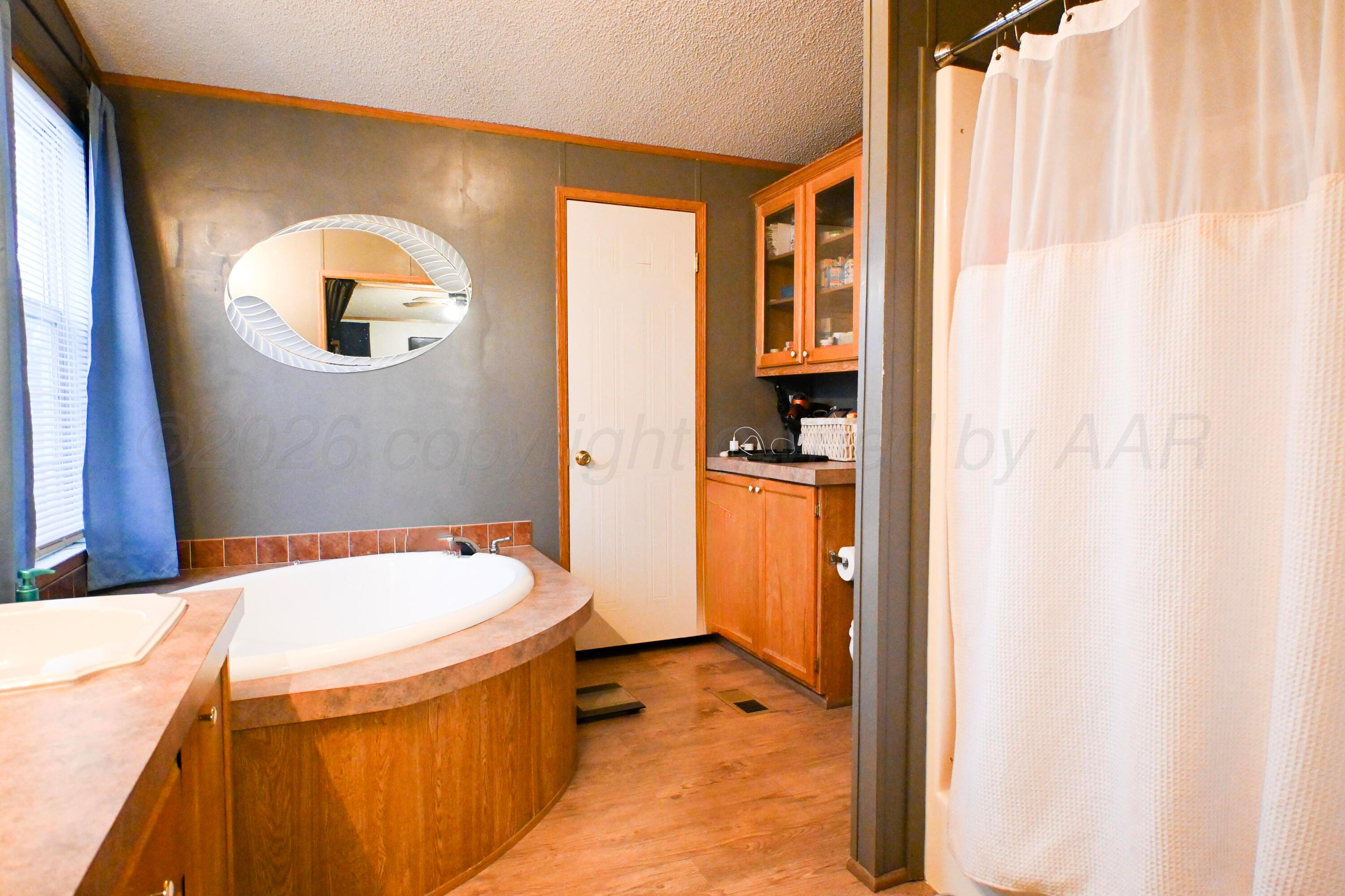 314 Cactus Road Borger, TX 79007 - Photo 11 of 28 a bathroom with a tub sink and mirror