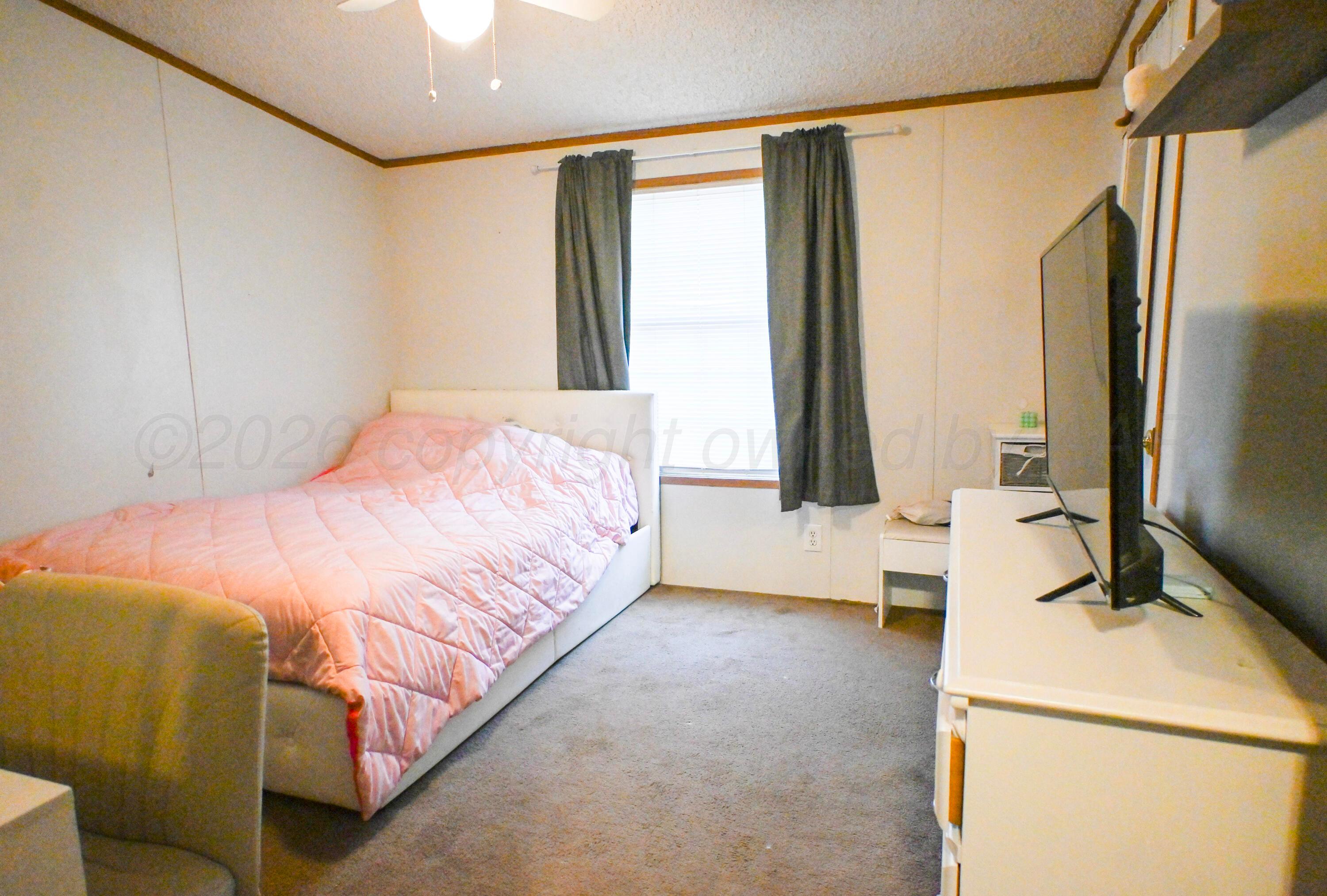 314 Cactus Road Borger, TX 79007 - Photo 12 of 28 a bedroom with a bed and a large mirror