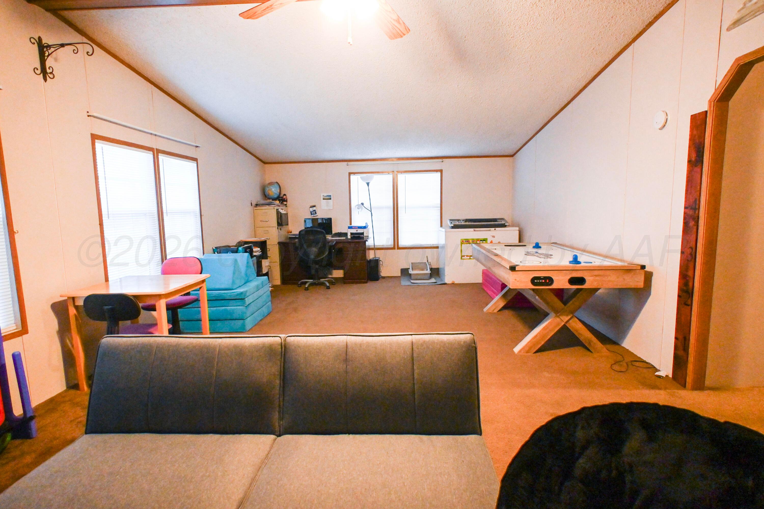 314 Cactus Road Borger, TX 79007 - Photo 19 of 28 a living room with furniture gym equipment and a large window