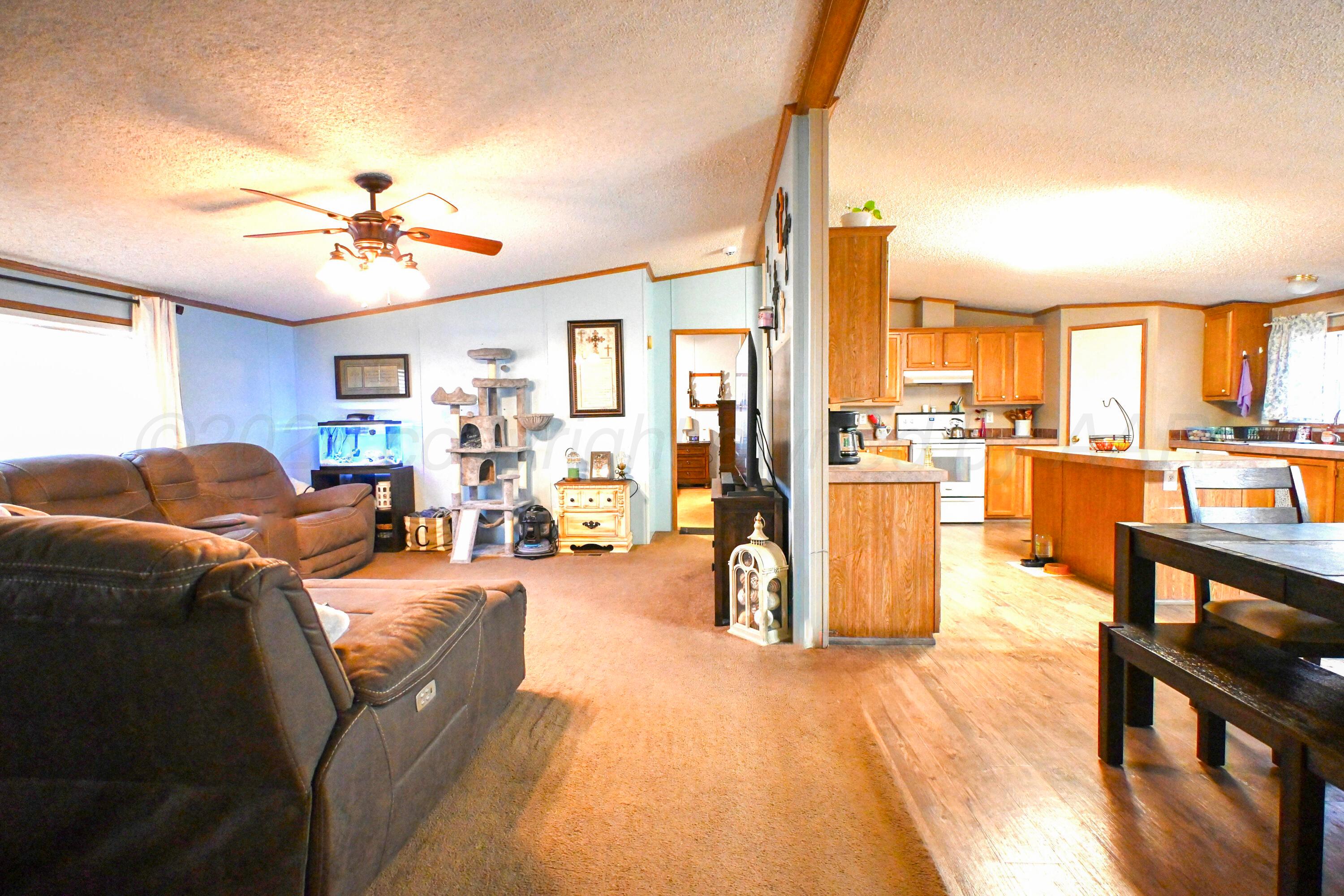 314 Cactus Road Borger, TX 79007 - Photo 5 of 28 a living room with furniture a wooden floor and a chandelier