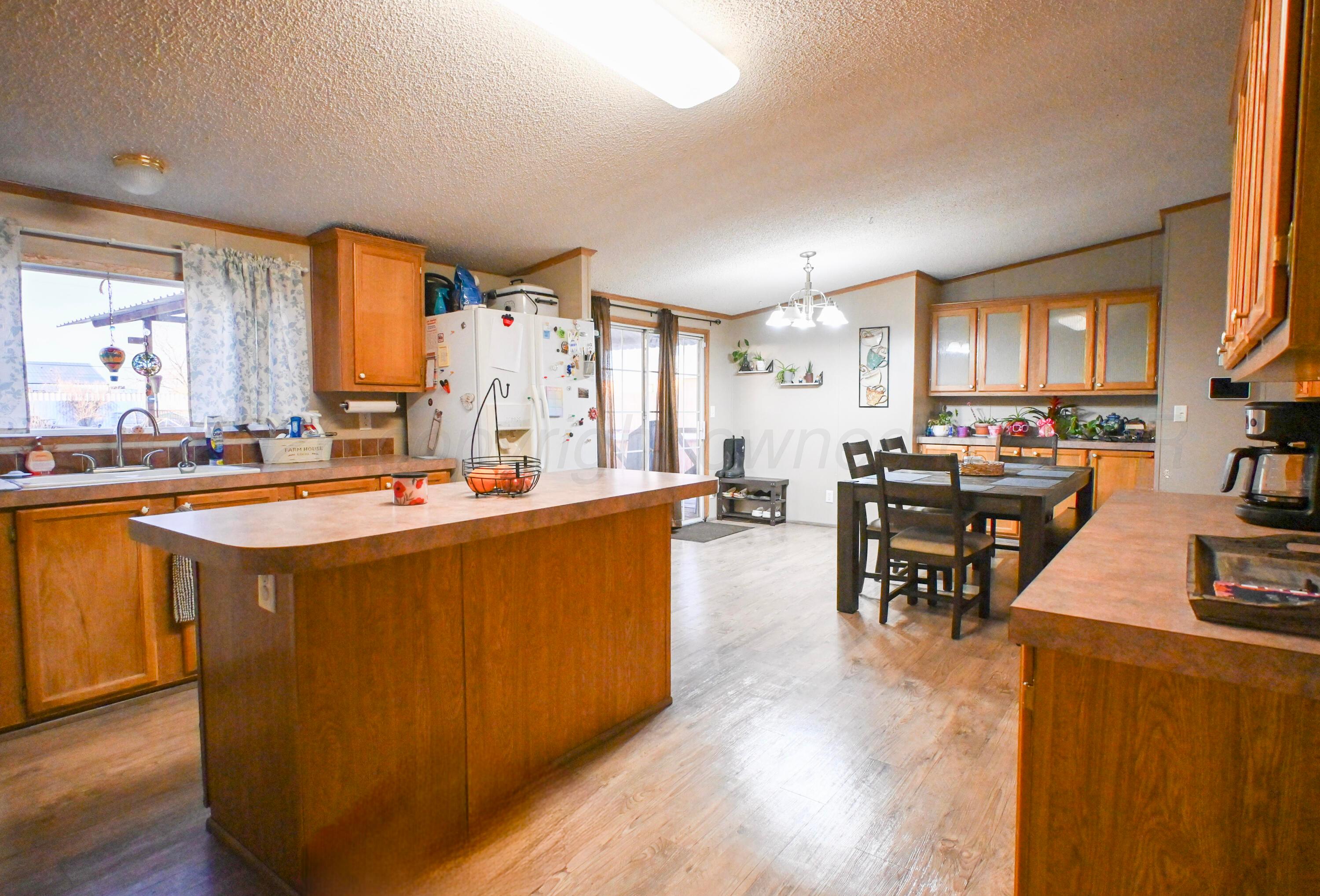 314 Cactus Road Borger, TX 79007 - Photo 6 of 28 a living room with stainless steel appliances kitchen island granite countertop a stove a sink a dining table and chairs