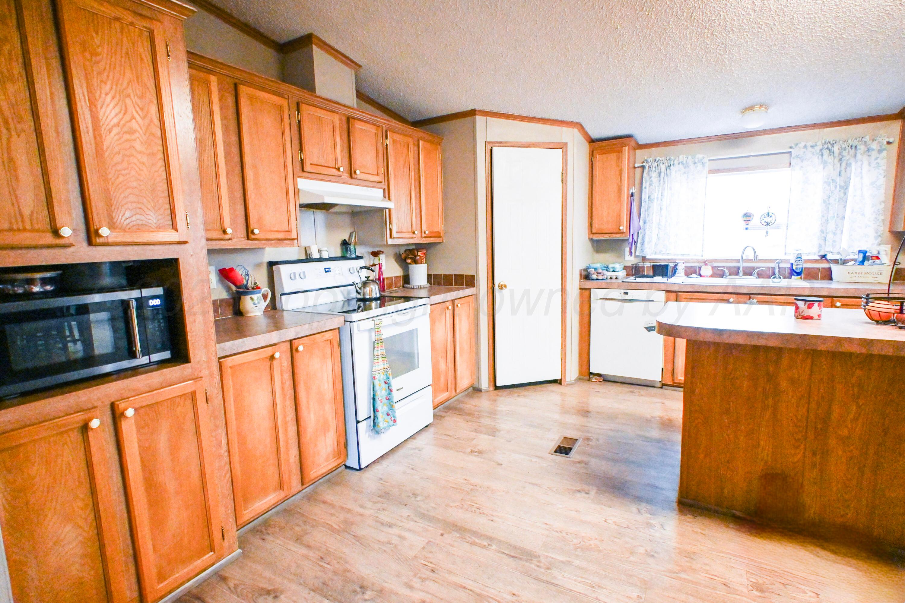 314 Cactus Road Borger, TX 79007 - Photo 7 of 28 a kitchen with stainless steel appliances a stove top oven and a refrigerator