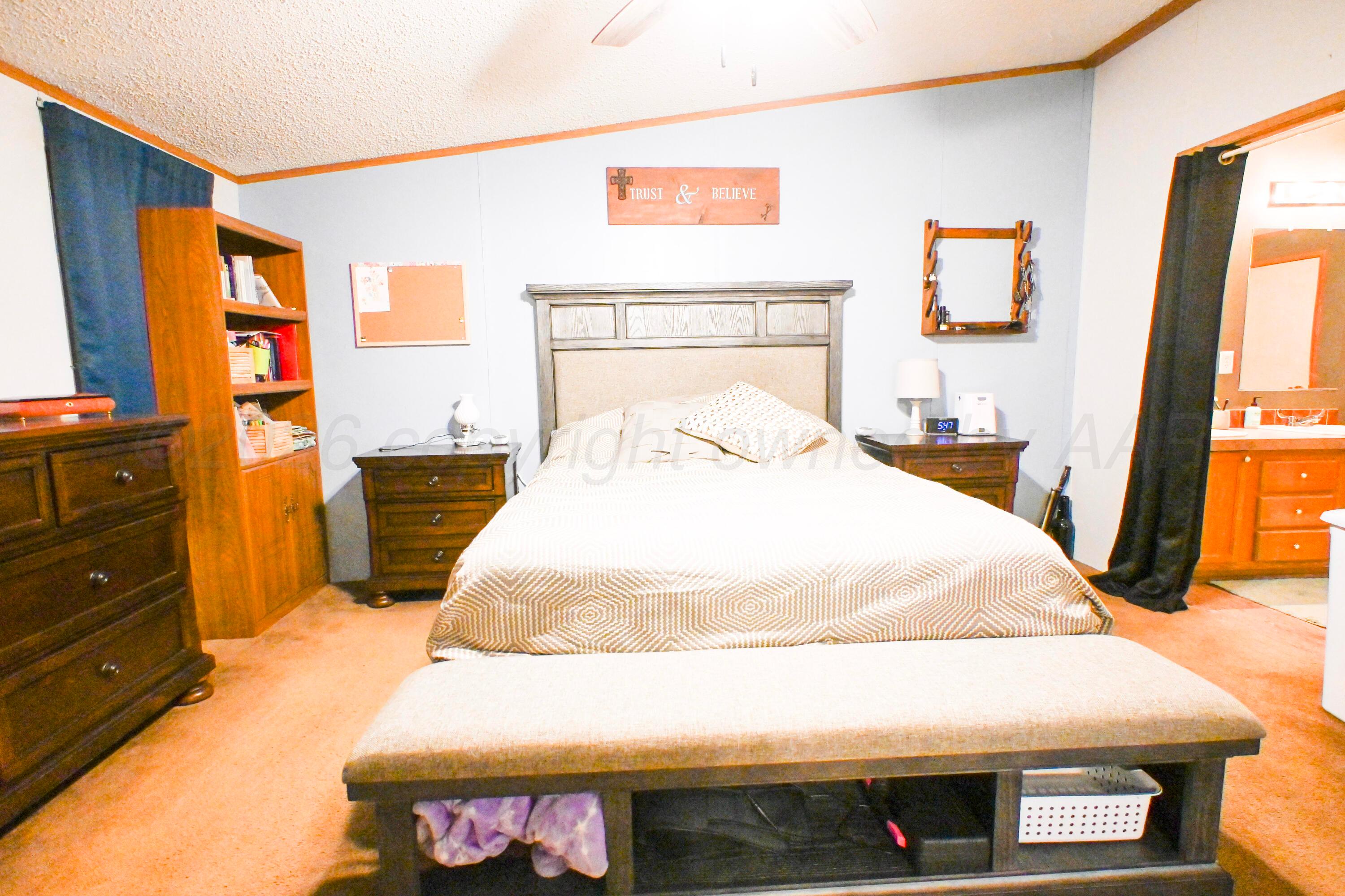 314 Cactus Road Borger, TX 79007 - Photo 9 of 28 a bedroom with a bed and a flat tv screen on dresser