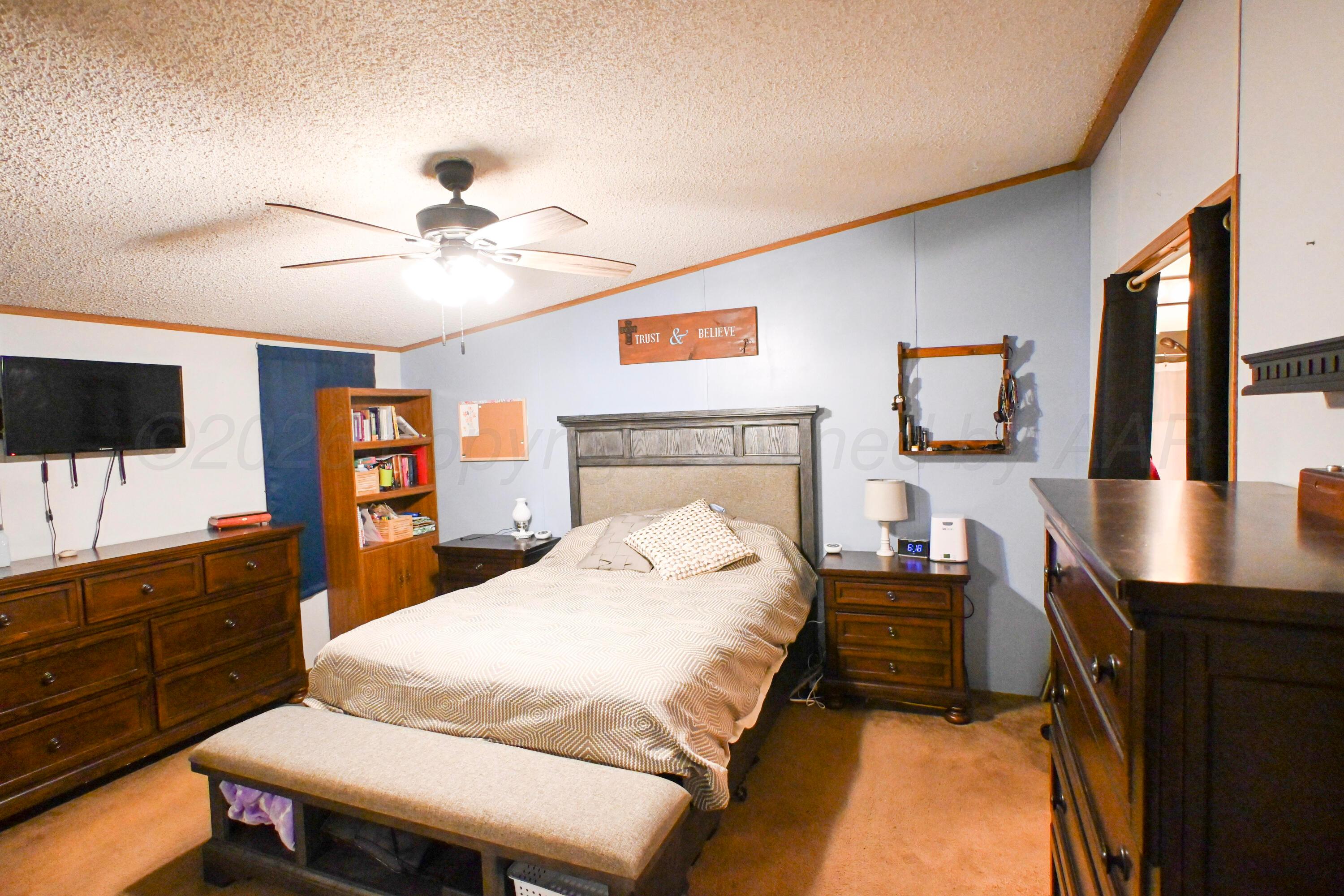 314 Cactus Road Borger, TX 79007 - Photo 10 of 28 a bedroom with a bed and a flat screen tv