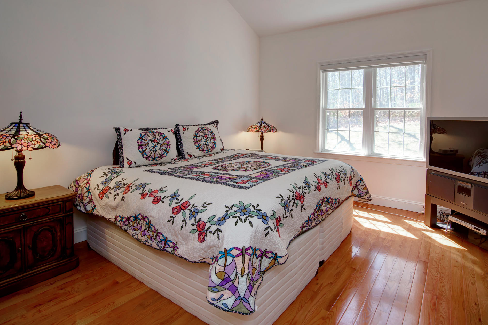 22 Stratford Ridge Mashpee, MA 02649 - Photo 13 of 35 a bedroom with a bed and a flat tv screen on a dresser