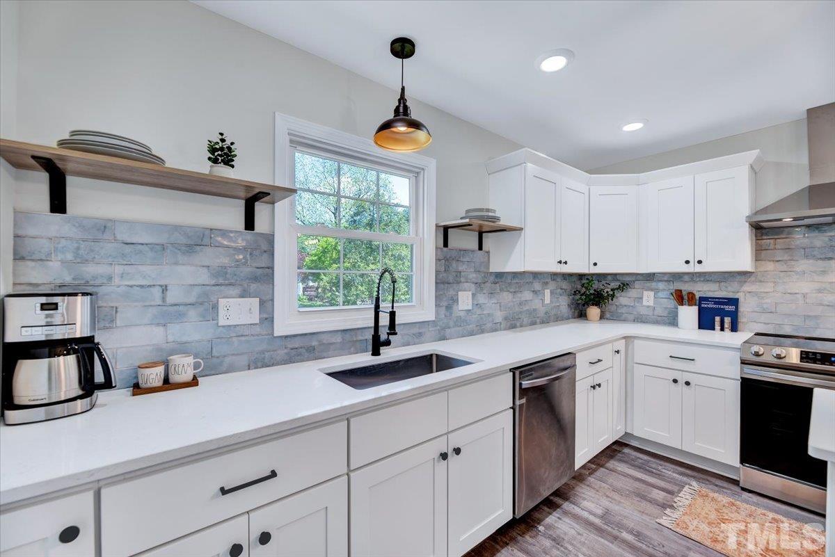962 Laurel Mill-Centerville Road Louisburg, NC 27549 - Photo 11 of 36 a kitchen with white cabinets a sink a window and appliances