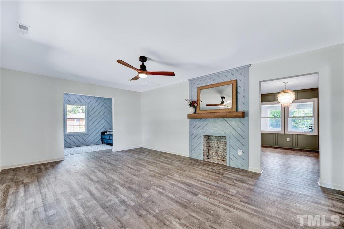 962 Laurel Mill-Centerville Road Louisburg, NC 27549 - Photo 5 of 36 a view of a livingroom with a fireplace a ceiling fan and wooden floor