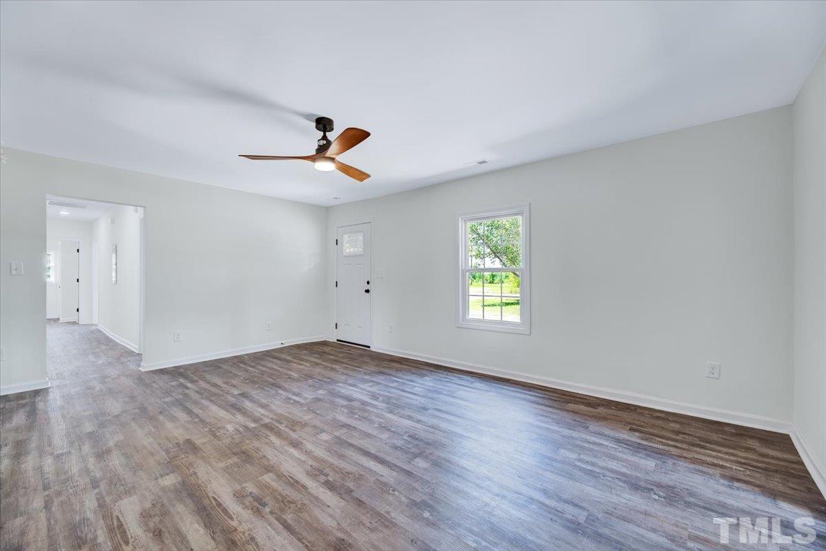 962 Laurel Mill-Centerville Road Louisburg, NC 27549 - Photo 7 of 36 an empty room with wooden floor and windows
