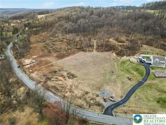 an aerial view of residential houses with outdoor space and trees