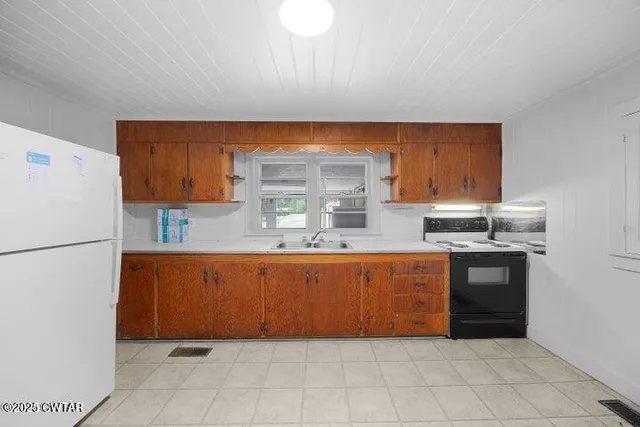 a kitchen with stainless steel appliances granite countertop a refrigerator sink and stove
