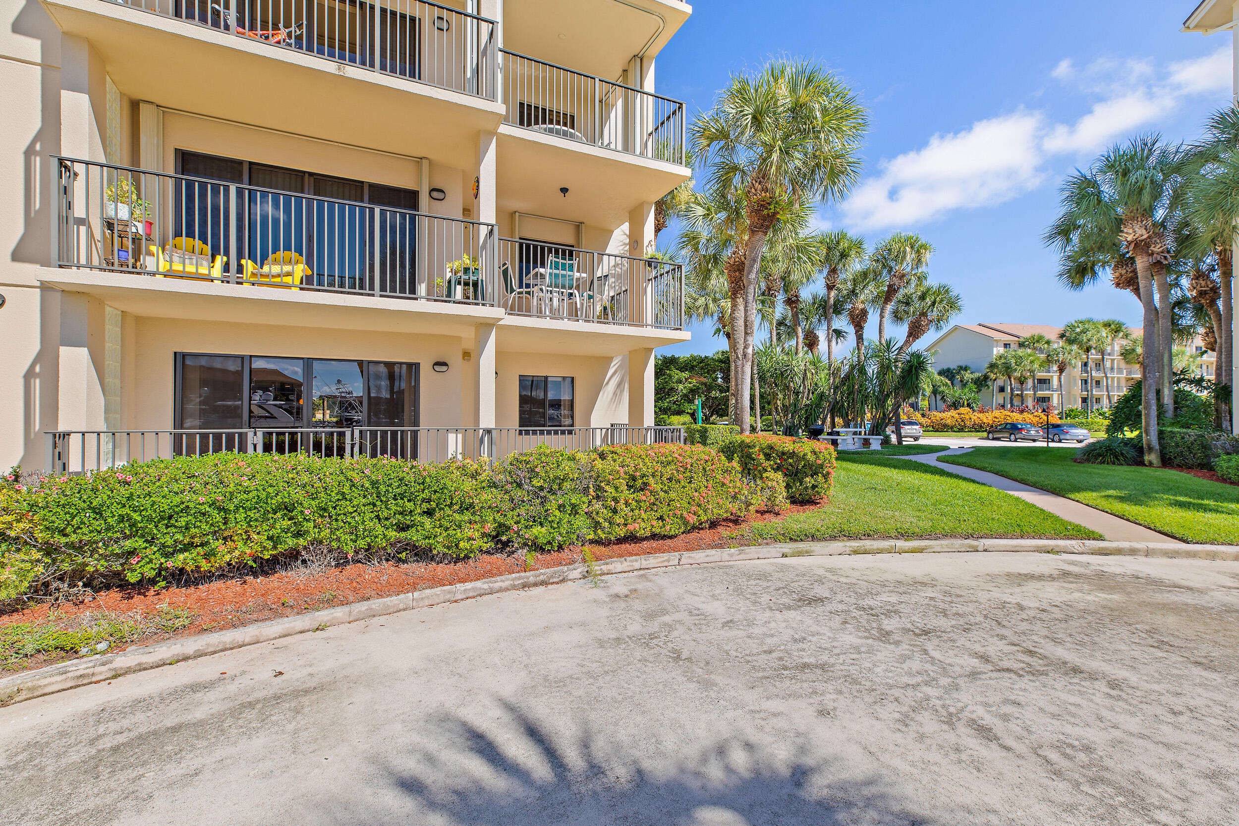 1501 Marina Isle Way, Unit 101 Jupiter, FL 33477 - Photo 19 of 25 a view of a building with a yard and plants