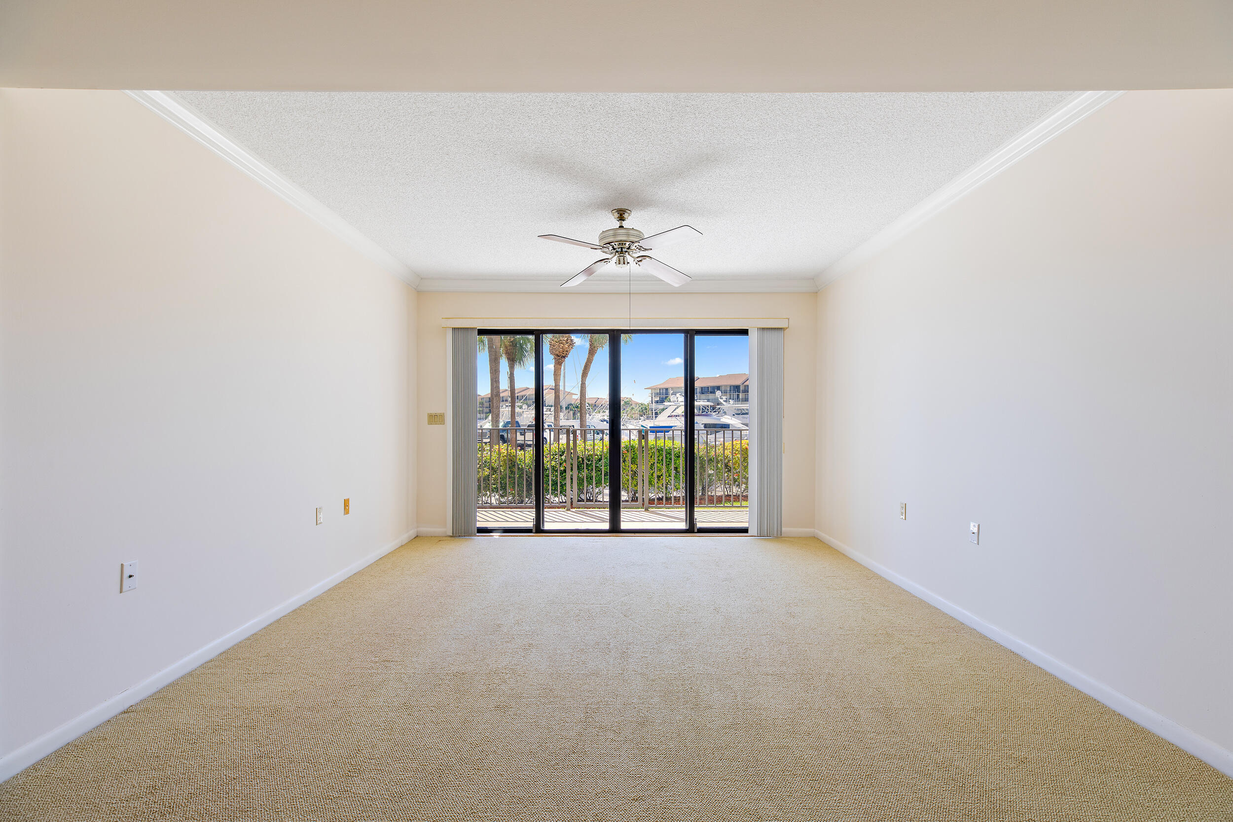 1501 Marina Isle Way, Unit 101 Jupiter, FL 33477 - Photo 7 of 25 an empty room with windows and ceiling fan