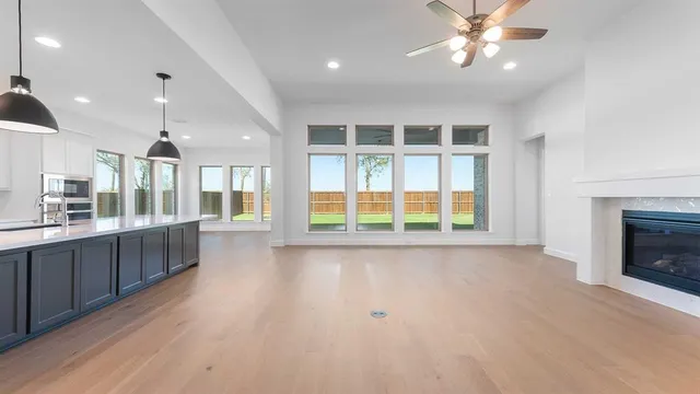 a view of an empty room with a kitchen and window