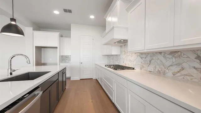 a kitchen with stainless steel appliances a sink stove top oven and cabinets