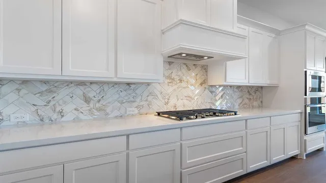 a kitchen with white cabinets and a stove