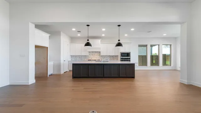 a large kitchen with a large counter top stainless steel appliances and a window