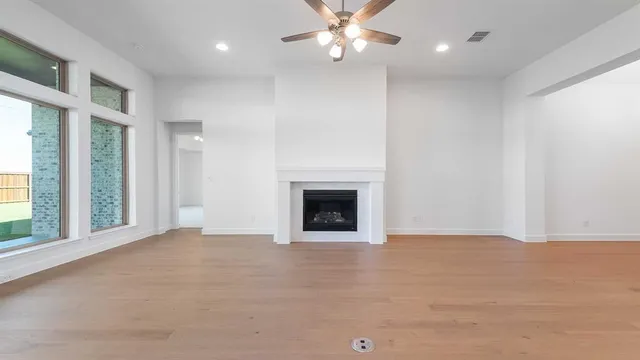 an empty room with windows and fireplace