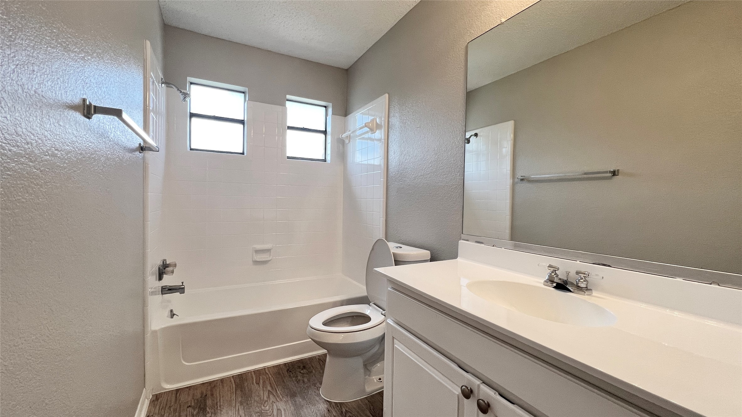 9201 Simmons Road, Unit 117 Austin, TX 78759 - Photo 18 of 20 Refined bath featuring a pristine white vanity, a large mirror, and classic tub/shower combination.