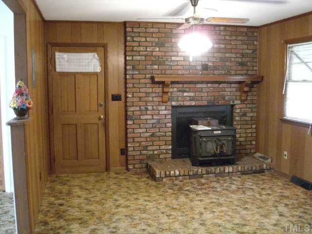 2994 Old Stage Road South Erwin, NC 28339 - Photo 7 of 12 Wonderful Masonry FP with Wood Stove Insert! You can convert this to Gas Logs if you Desire. Door leads to Attached Garage w/Storage. This paneling would look beautiful painted!