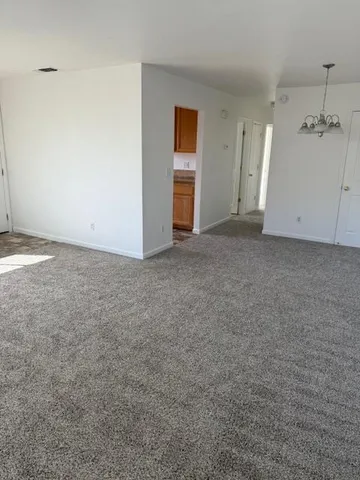 an empty room with an entryway and wooden floor